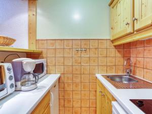 eine Küche mit einer Spüle und einer Mikrowelle in der Unterkunft Apartment Chanteneige La Croisette-4 by Interhome in Les Menuires
