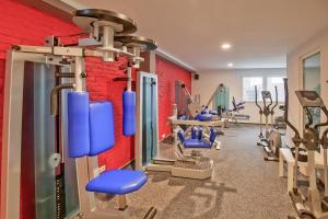 a gym with blue chairs and tread machines at Hotel Im Schützenhof, Jever in Jever