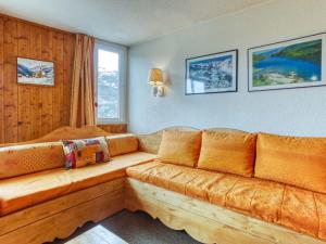 ein Wohnzimmer mit einem Holzsofa im Zimmer in der Unterkunft Apartment Chanteneige La Croisette-4 by Interhome in Les Menuires