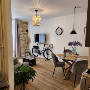 a living room with a table and a clock on the wall at L' atelier du 26 in Dinan