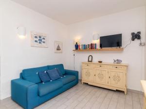 un soggiorno con un divano blu e una TV di Apartment Trudi by Interhome a Cannigione