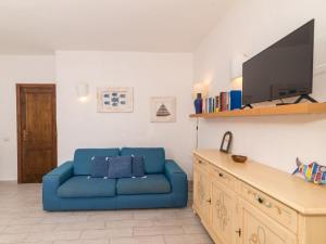 un divano blu in un soggiorno con una TV di Apartment Trudi by Interhome a Cannigione Altre 22 foto