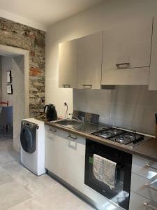 una cucina con piano cottura e lavatrice di Villa Bacchetta - Stone Cottage a Oleggio Castello