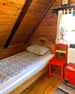 a bedroom with a bed and a red chair at Vila Tornik in Zlatibor