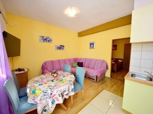 sala de estar con mesa y sofá rosa en Holiday Home Mario-2 by Interhome, en Makarska