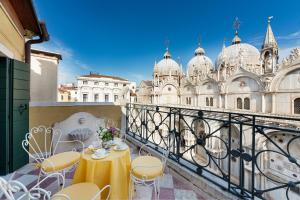 un balcone con tavolo e sedie e un edificio di Due Leoni Terrace In St Mark's Square a Venezia