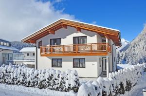 a house with a balcony in the snow at Appartement Leiter in Niederthai