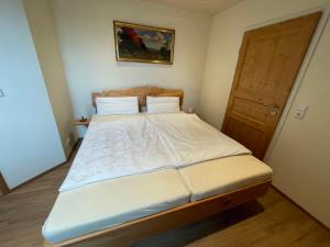 ein kleines Schlafzimmer mit einem Bett mit weißer Bettwäsche in der Unterkunft Apartment Storchennest by Interhome in Meißenheim