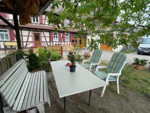 zwei Stühle und ein Tisch und eine Bank in einem Hof in der Unterkunft Apartment Storchennest by Interhome in Meißenheim