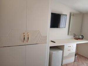 a kitchen with white cabinets and a desk at Gurtas Hotel in Antalya