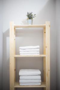 a wooden shelf with white towels on it at Casa con pozo Platamonas in Platamonas