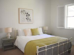a bedroom with a bed and two lamps and a window at Maleny Homestead & Cottage in Maleny