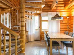 a dining room with a wooden table and a staircase at Holiday Home Täperän torppa by Interhome in Nilsiä