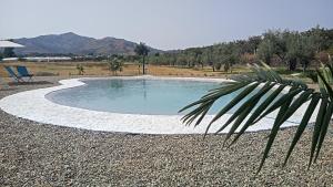 a small swimming pool in the middle of a field at Minissale Farmhouse in Calatabiano