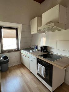 uma cozinha com armários brancos e um forno com placa de fogão em DO One Bedroom Flat em Dortmund