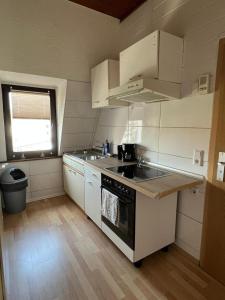 cocina con armarios blancos y fogones en DO One Bedroom Flat, en Dortmund