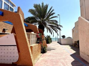 a sidewalk next to a building with a palm tree at Estudio Naturista Indalo in Vera