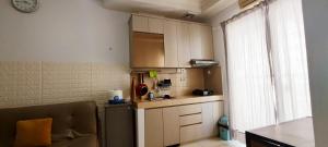 a small kitchen with a sink and a refrigerator at Spacious & Cozy 27FL - 2BR Apartment West Jakarta in Jakarta