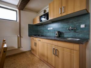 ハルラホフにあるApartment Harrachov 387 by Interhomeの木製のキャビネットとシンクを備えたキッチン +35枚の写真