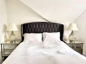Lovely Central Horsham Home في هورشام: غرفة نوم مع سرير مع مواقف ليلتين