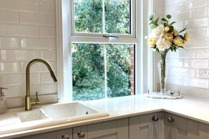 a kitchen with a sink and a vase of flowers at Lovely Central Horsham Home in Horsham