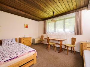 a bedroom with a bed and a table and chairs at Apartment Harrachov 387 by Interhome in Harrachov