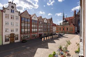 a street in a city with buildings and tables at Downtown Apartments Old Town Paradise Lost in Gdańsk