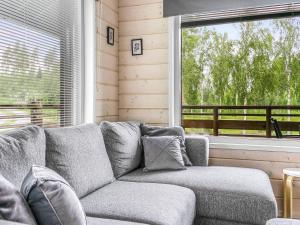 a living room with a couch and a large window at Holiday Home Himoksen keiju 1 by Interhome in Jämsä +14 photos