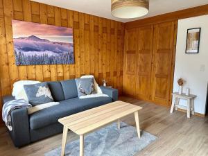 ein Wohnzimmer mit einem blauen Sofa und einem Tisch in der Unterkunft Apartment Parc B428 by Interhome in Champex
