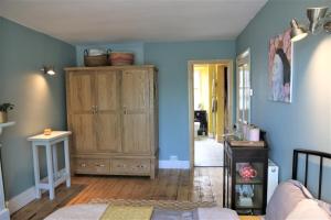 a bedroom with blue walls and a wooden cabinet at Dolafon in Llanbedr