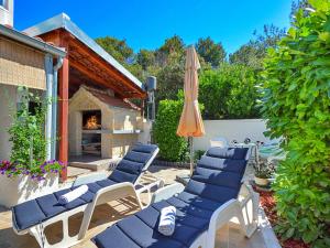 a group of chairs and an umbrella on a patio at Holiday Home Gabi by Interhome in Brodarica