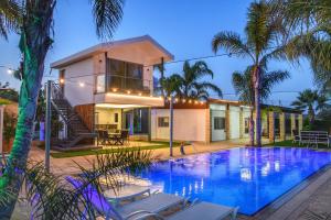 a house with a swimming pool in front of a house at Oasis By The Sea - Cyprus in Larnaka