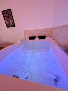 eine große Badewanne mit blauem Wasser in einem Zimmer in der Unterkunft A0 Grand Appartement, Jaccuzi, et extérieur Thermal Artem à 200m in Nancy