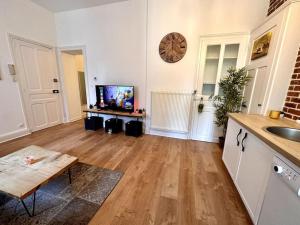 ein Wohnzimmer mit einem Tisch und einem Fernseher an der Wand in der Unterkunft A0 Grand Appartement, Jaccuzi, et extérieur Thermal Artem à 200m in Nancy + 13 Fotos