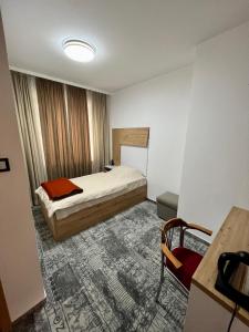 a bedroom with a bed and a table and a desk at Hotel Brkic in Sarajevo