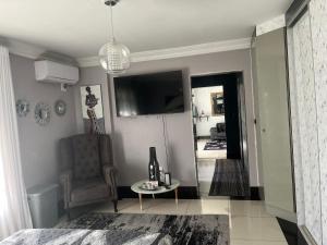 sala de estar con silla y mesa en Umhlanga Guesthouse flat, en Durban