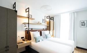 um quarto de hotel com duas camas e uma janela em Esteem Tour Eiffel em Paris