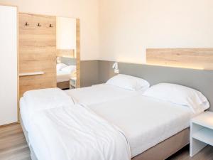 een slaapkamer met een groot wit bed en een spiegel bij Apartment Panorama-1 by Interhome in Costermano