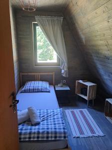 a bedroom with two beds and a window at ZlatAir Eco Chalet in Nova Varoš