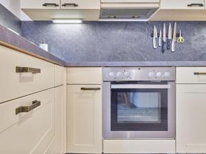 a kitchen with white cabinets and an oven at Apartment Marika 1 by Interhome in Černý Dŭl +32 photos