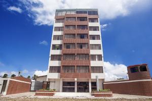 a tall brick building with windows on top of it at Boreas Apart Hotel in Fortaleza