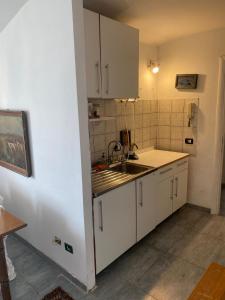 kuchnia z białymi szafkami i zlewem w obiekcie Apartment in Roma with Terrace w Rzymie