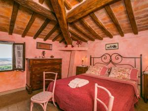 a bedroom with a red bed and two chairs at Holiday Home Antica Pietra by Interhome in La Cava