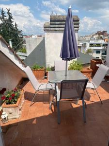 a table and chairs with an umbrella on a roof at Apartment in Roma with Terrace in Rome