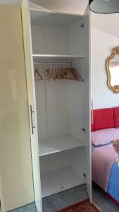 a closet with white cabinets next to a bed at Apartment in Roma with Terrace in Rome