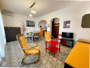 ein Wohnzimmer mit gelben Stühlen und einem Tisch in der Unterkunft Vintage-modern gem with private garden in Porto Santa Margherita