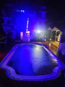 an empty swimming pool at night with blue lights at Goa Divine Candolim in Calangute