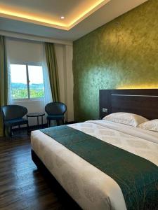 a hotel room with a large bed and a window at Malibest Premier in Pantai Cenang