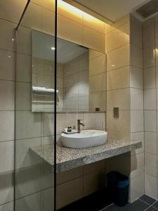 uma casa de banho com um lavatório e um espelho em Malibest Premier em Pantai Cenang