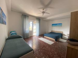 a bedroom with two beds and a ceiling fan at APPARTAMENTO CENTRALE SANTA MARINELLA in Santa Marinella